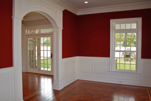 Dining room walls painted a deep red above the wainscoting