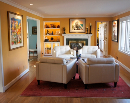 Warm, yellow-orange wall color connects the living room decor