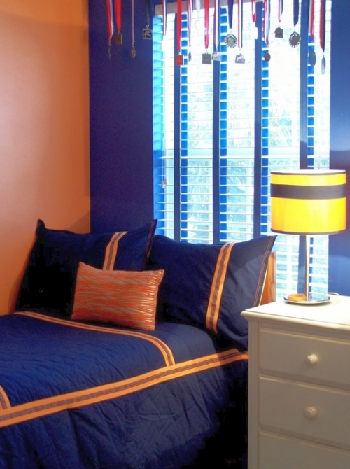 Teenage boy's orange bedroom with a deep royal blue accent wall
