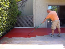 Alek is applying deck stain