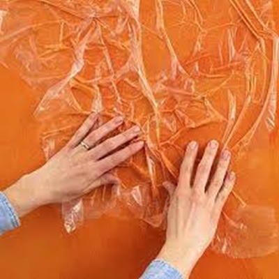 Rag painting a wall with a sheet of plastic