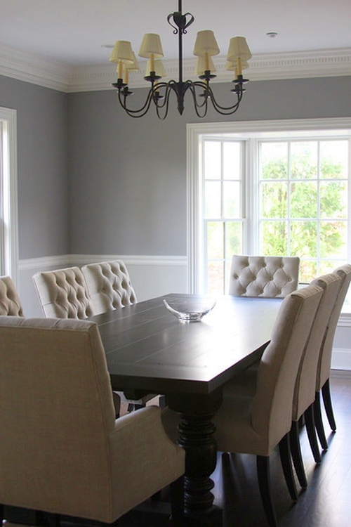 Gray dining room walls are offset by white wainscoting and cream furniture