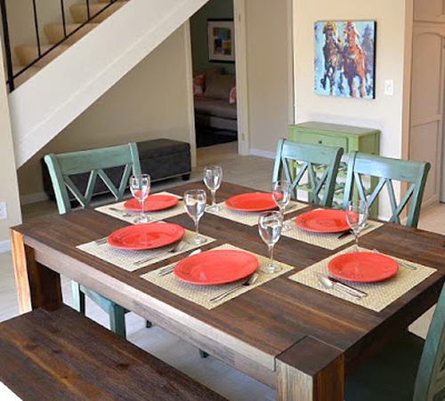 Open dining room painted beige with red and green colorful accessories