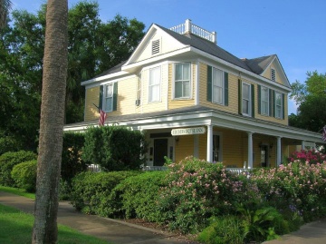 House exterior painted in a yellow and green color scheme
