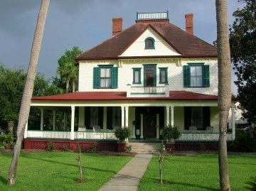 Brick house painted white, green and red