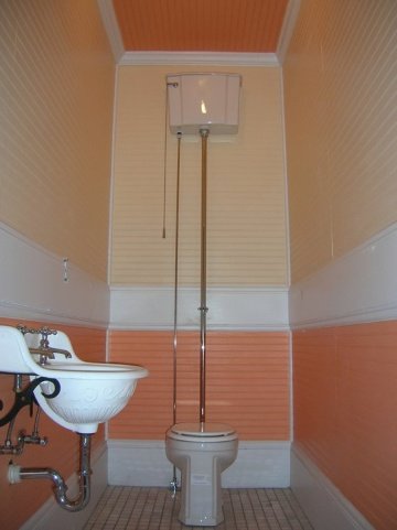 Powder room ceiling and walls painted in different shades of orange