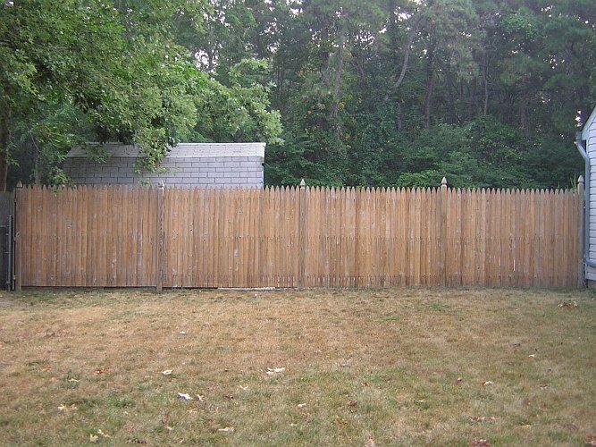 Before: bare wood fence