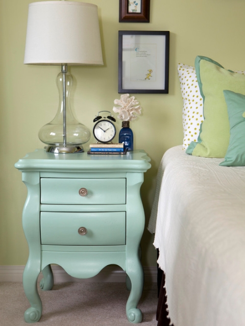 Bedroom walls painted green with turquoise and off-white decor accents