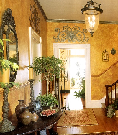 Sponged off foyer walls in shades of gold, decorated with stencil designs